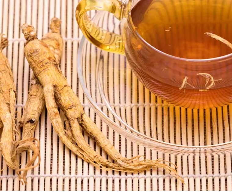 Peaceful person sleeping beside a cup of ginseng tea